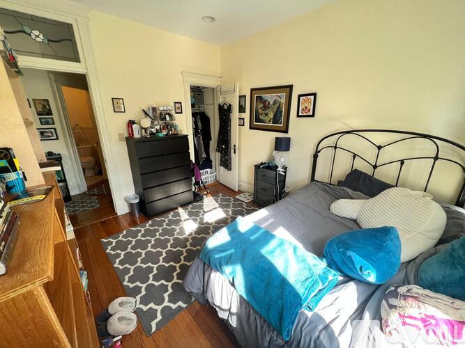 A bedroom with a bed, dresser, and mirror.