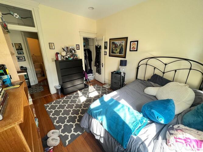 A bedroom with a bed, dresser, and mirror.