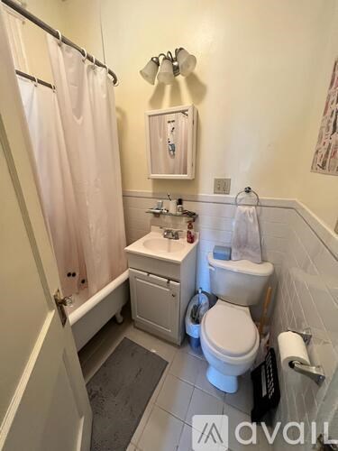 A white toilet sits in a bathroom next to a white sink.