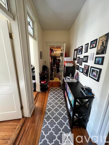 A hallway with a black table and pictures on the wall.
