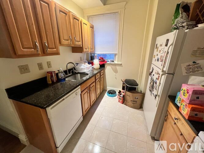 A kitchen with wooden cabinets and a black countertop.