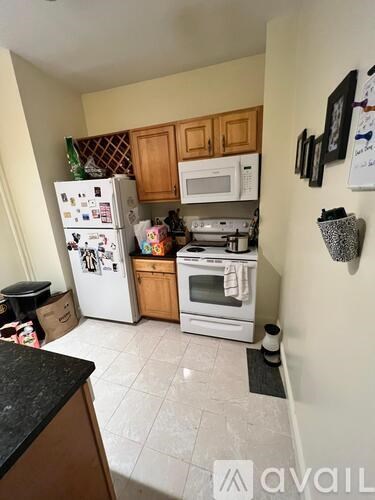 A kitchen with a white fridge and a black counter.