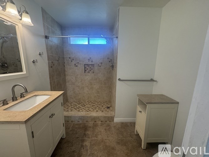 A bathroom with a sink, mirror, and tiled floor.