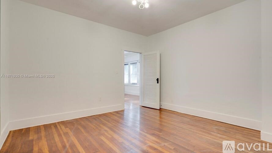 A room with wooden flooring and white walls.