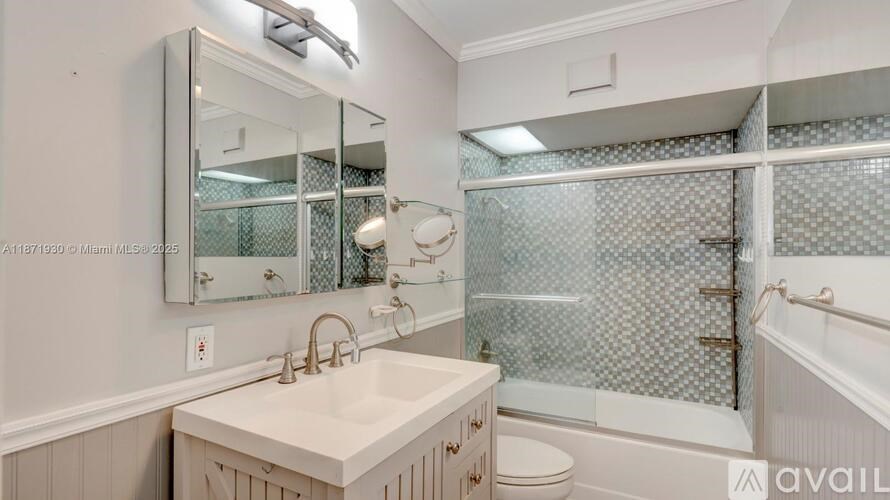 A bathroom with a sink, mirror, and shower.