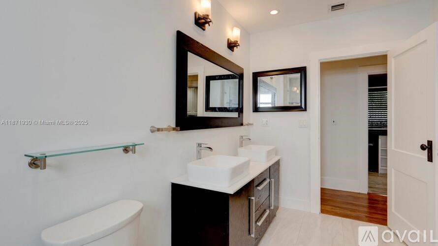 A bathroom with a white sink and a large mirror above it.