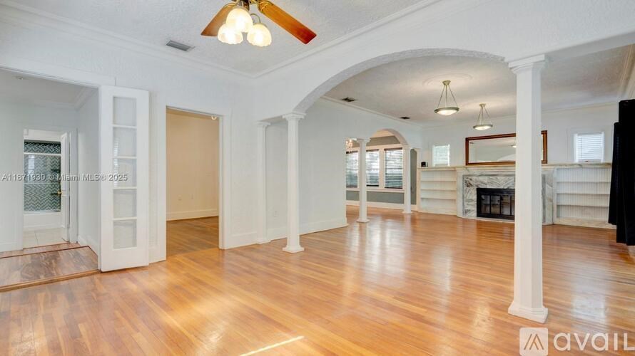 A spacious room with wooden floors and white walls.
