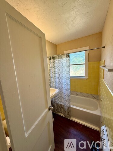 A bathroom with a white door and a yellow wall.