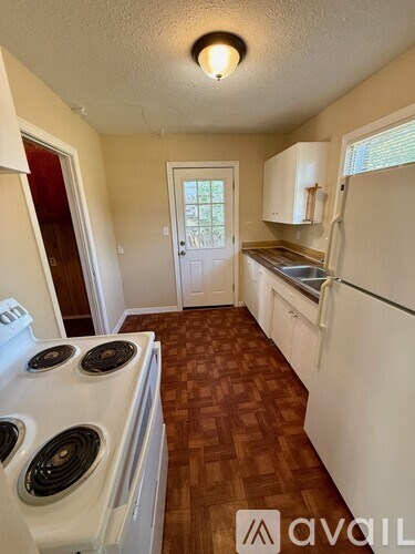 A kitchen with a white stove and white cabinets.