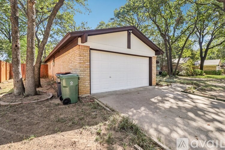 A two-car garage with a white door is situated in a residential area.
