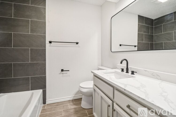 A bathroom with a white toilet, a white sink, and a white bathtub.