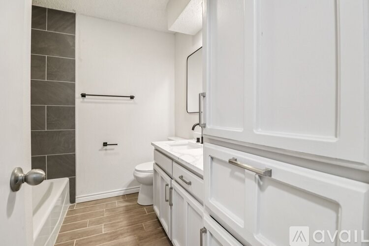 A bathroom with a toilet, sink, and a shower.