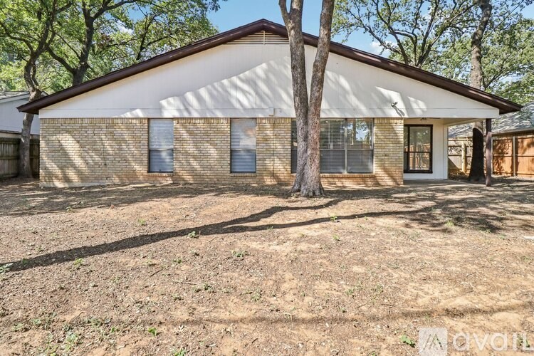 A house with a brown roof and a tree in front.