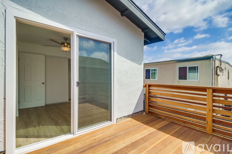 A balcony with a sliding glass door and a ceiling fan.