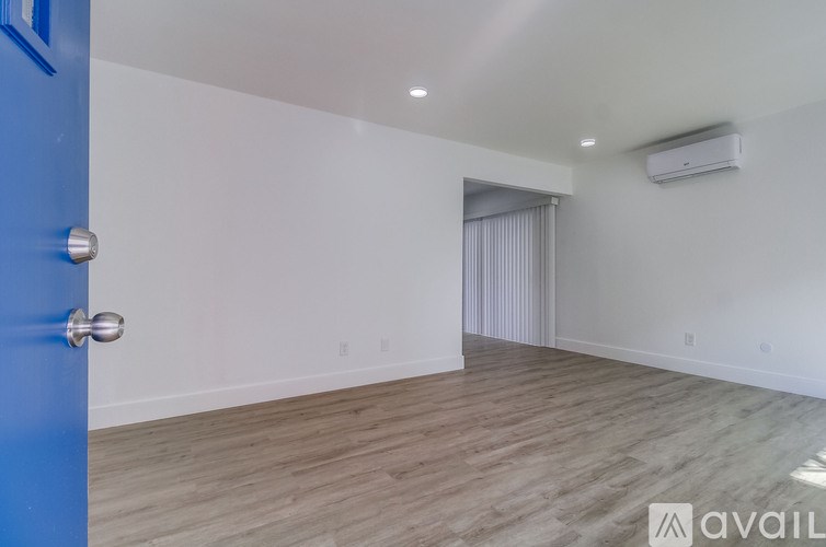 A room with a blue door and wooden flooring.