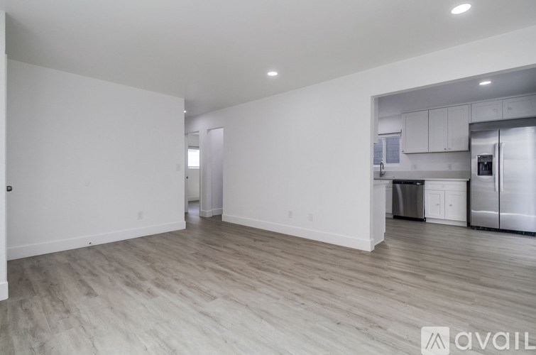 A spacious kitchen with white cabinets and stainless steel appliances.