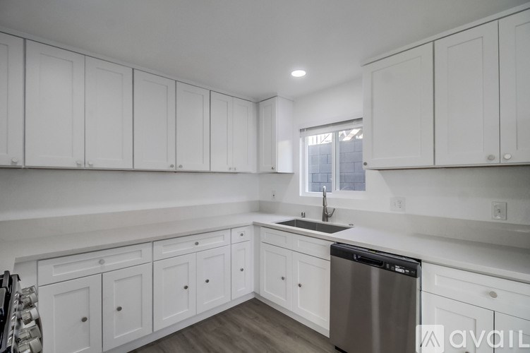 A kitchen with white cabinets and a stainless steel dishwasher.