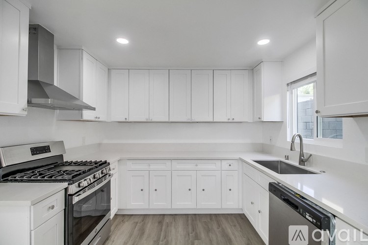 A modern kitchen with white cabinets and a stainless steel dishwasher.