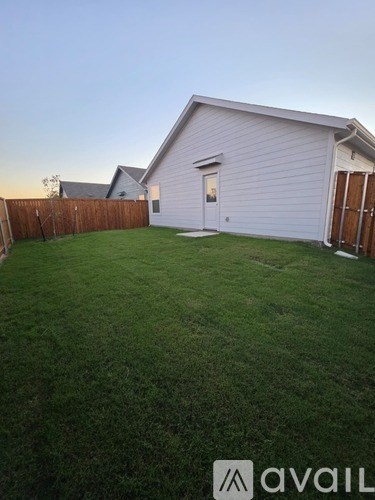 A house with a white siding and a brown fence is shown.