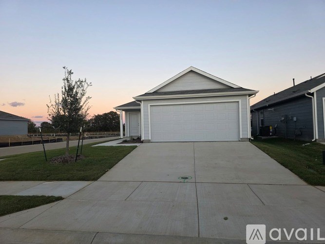 A two-car garage with a white door is situated in a residential area.