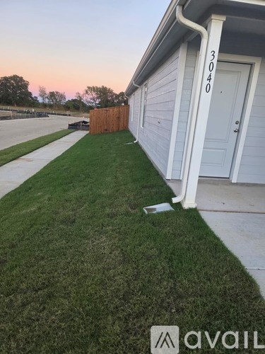 A house numbered 3040 is shown with a white door and a small white sign on the lawn.