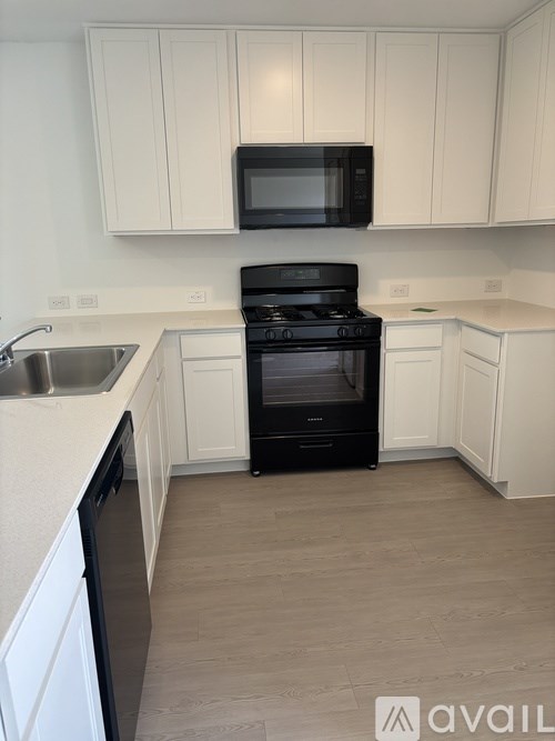 A black oven and microwave in a white kitchen.