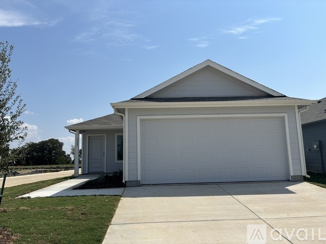 A white garage with a grey roof and a white door.