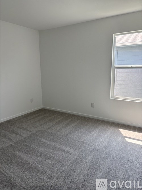 A room with a carpeted floor and a window.