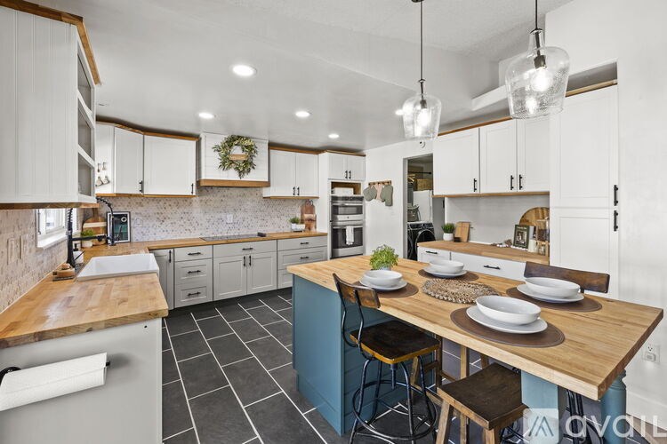 A kitchen with a table set for two with plates and glasses on it.