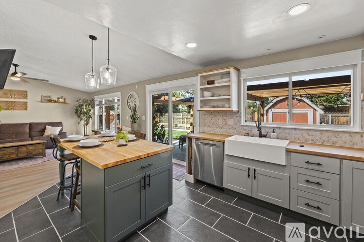 A kitchen with a wooden island and grey cabinets.