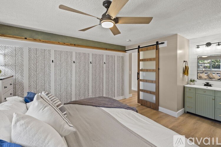 A bedroom with a bed, dresser, and a ceiling fan.