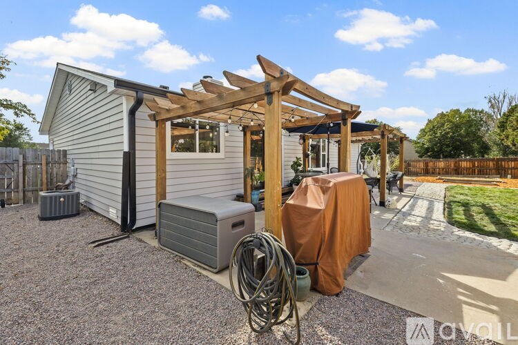 A house with a wooden pergola attached to it.