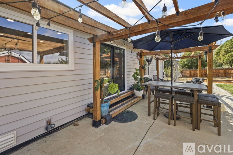 A patio area with a table and chairs under a pergola.