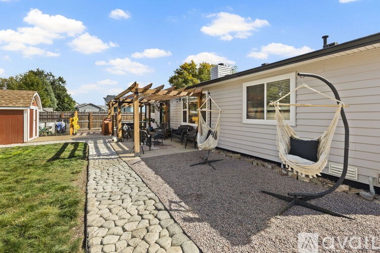 A backyard with a swing set and a gravel path.