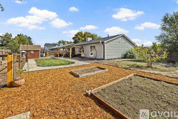 A backyard with a shed, a fence, and a garden.