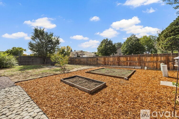 A backyard with a gravel area and a small garden bed.