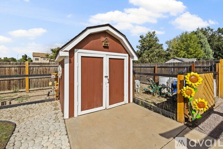 A small brown shed with a brown door and a sign on the front.