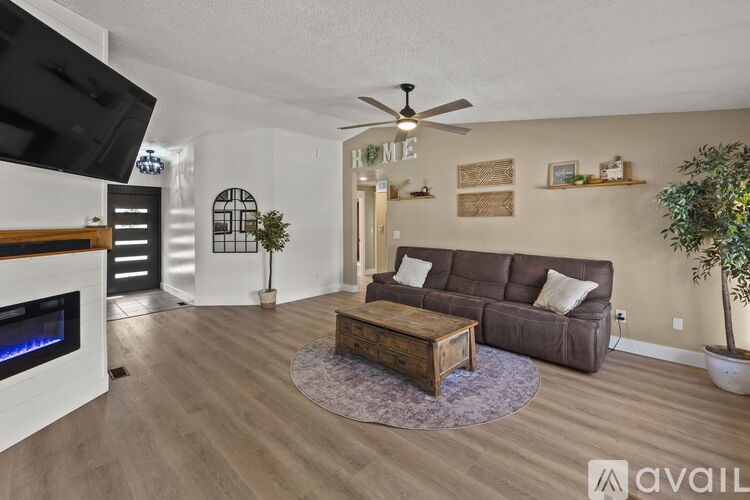 A living room with a brown couch, a wooden coffee table, and a fireplace.