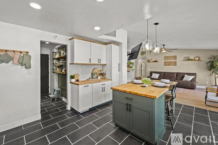 A kitchen with a wooden island and white cabinets.