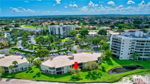 A bird's eye view of a residential area with a red arrow pointing to a specific house.