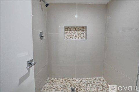 A bathroom with a shower and a tiled floor.