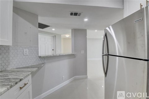 A kitchen with white cabinets and a marble countertop.