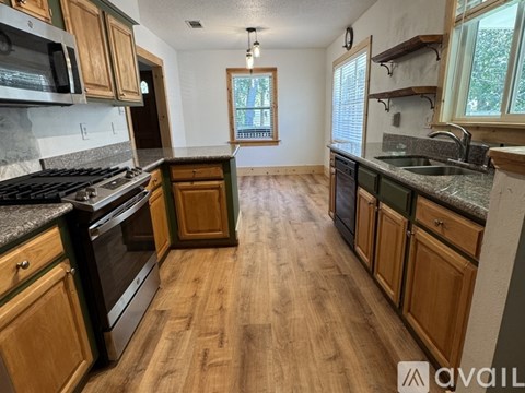 A kitchen with wooden cabinets and a black stove top oven.