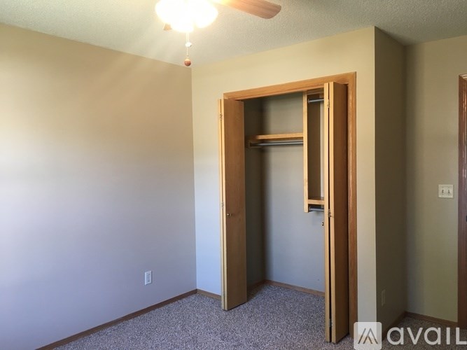 A room with a ceiling fan and a door that opens to a closet.