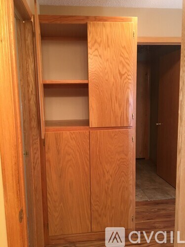 A wooden shelving unit with four shelves is open.