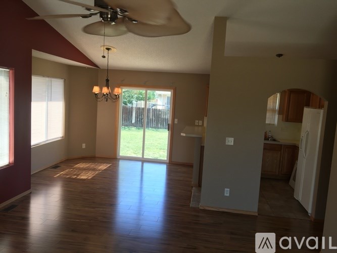 A room with a ceiling fan and wooden flooring.