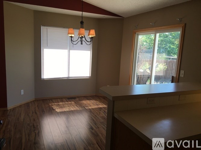 A room with wooden floors and a window with blinds.