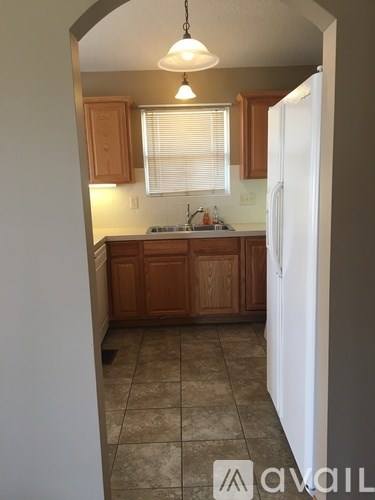 A kitchen with wooden cabinets and a white refrigerator.