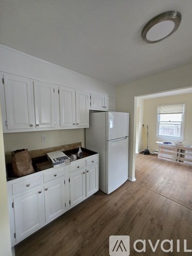 A kitchen with white cabinets and a white refrigerator.