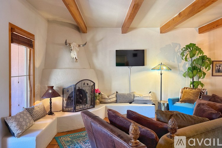 A living room with a white couch and a skull decoration on the wall.